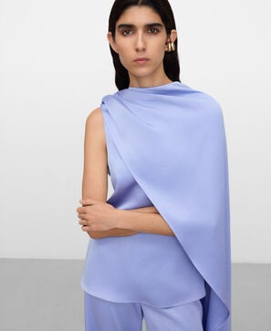 Peplum top with asymmetric overlaid cape